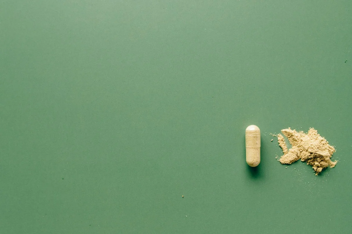 Calcium supplement capsule and powder on a green background