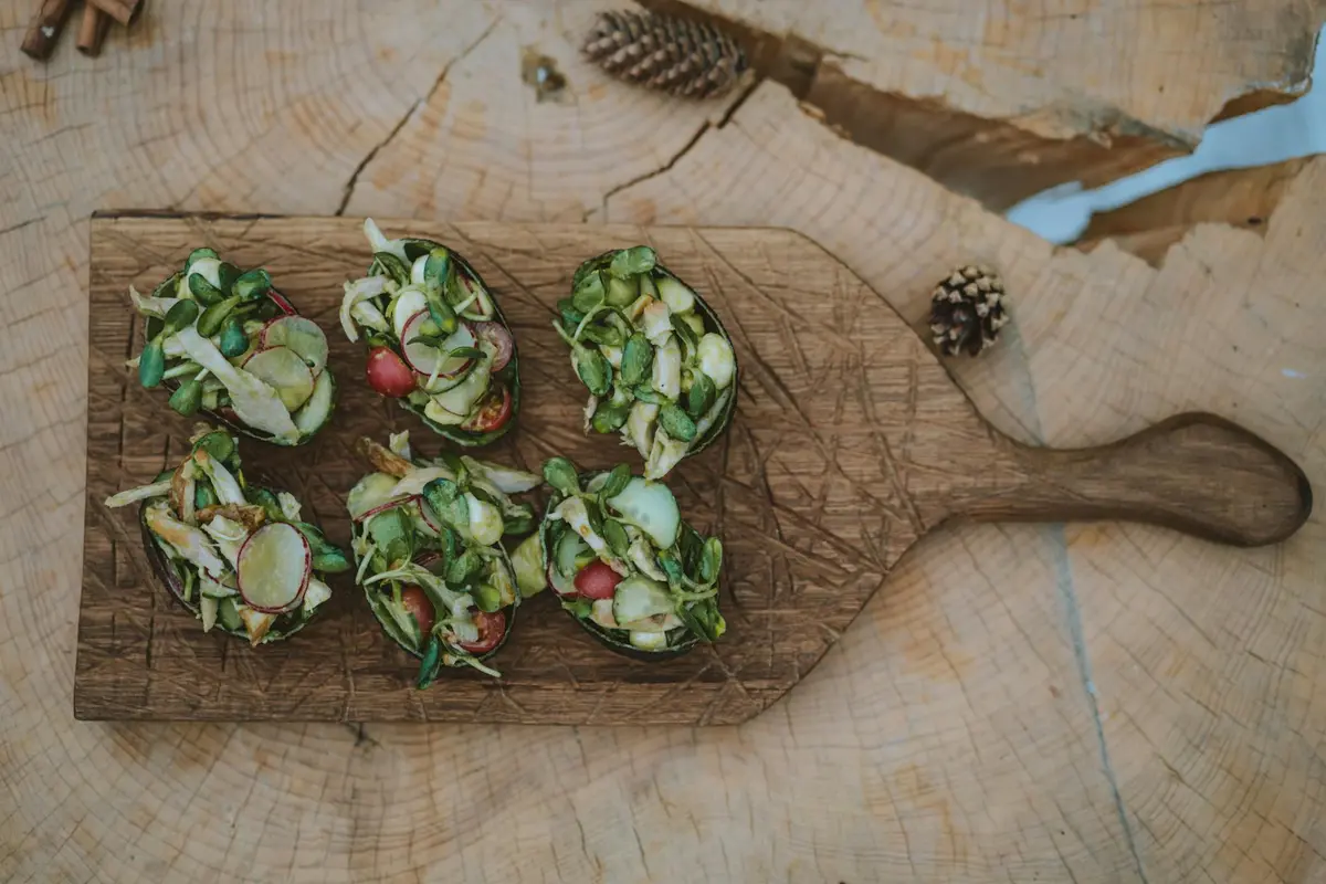 Portioned spring mix salad on a wooden board, prepared in small cups
