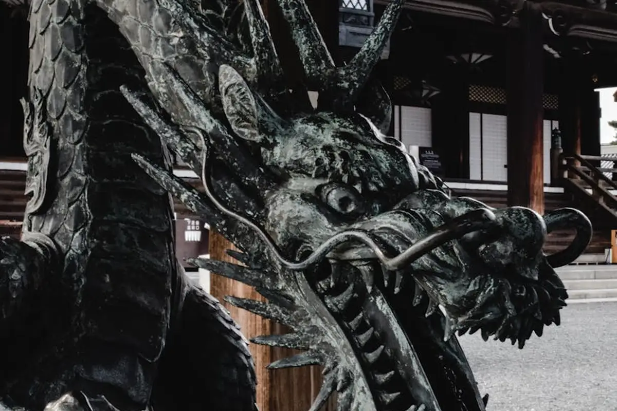 Bronze dragon statue at a temple with intricate scales and a long snout