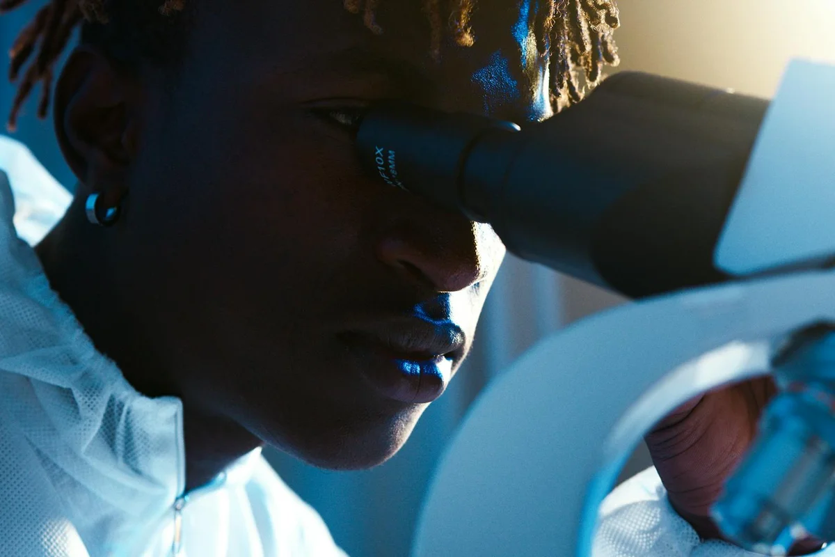 Close-up of a researcher looking into a microscope, highlighting laboratory analysis for parasite testing.