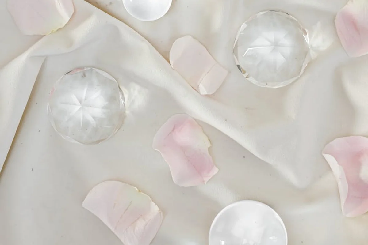 Soft pink rose petals scattered on a light cloth background